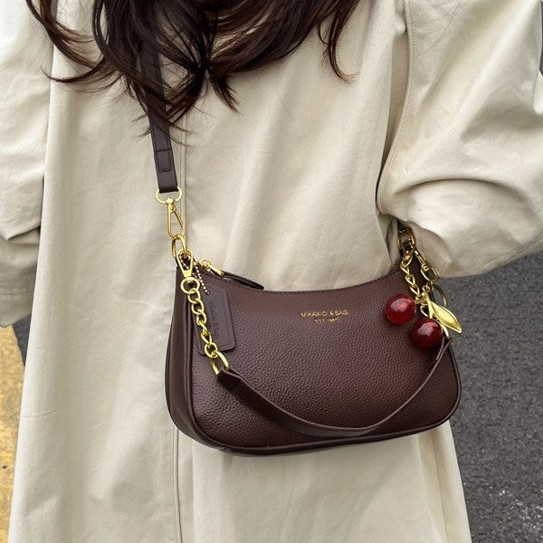 Brown PU dumpling crossbody bag with pendant and gold chain strap; small size with zipper closure.