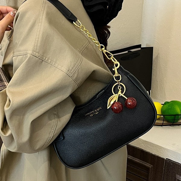 Black PU one-shoulder crossbody dumpling bag with gold chain and cherry pendant.